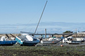 A row of boats docked at a pier with a clear view of the water and distant mountains. - Apartment on Côte d’Amour near La Baule Beach (PORNICHET)