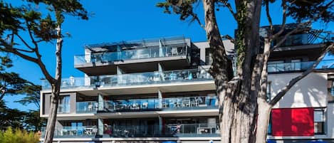 A multi-story building with outdoor seating and a clear blue sky.