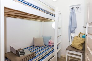 A bunk bed with a laptop on the lower bunk, a teddy bear, and a bag on a chair. - Apartment on Côte d’Amour near La Baule Beach (PORNICHET)