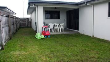 Enjoy outdoor dining and socializing in this patio area with a table and chairs.