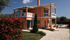 A two-story house with a balcony, a swimming pool, and a stone pathway. - VILLA PANTHEON, SYVOTA BAY, LEFKADA (SYVOTA LEFKADA)