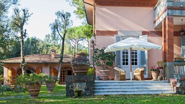 A villa with a patio, outdoor seating, and potted plants. - Holiday Home for 5 People, Garden, 500m till Sea, A/C, WIFI, near Forte dei Marmi (Marina Dei Ronchi)