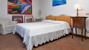 A bedroom with a bed, a nightstand, a chair, a painting, and a lamp. - Holiday Home for 5 People, Garden, 500m till Sea, A/C, WIFI, near Forte dei Marmi (Marina Dei Ronchi)