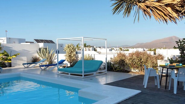 A rooftop pool with a blue lounge chair and a white canopy structure. - Villa Perla Blanca, 3 bed, free wifi, airco & heated pool (Playa Blanca)