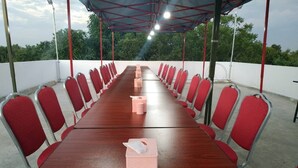 A conference room with a long wooden table and red chairs. - Grand Diamond Guest House (Mingaladon Township)