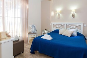 Una habitación de hotel con cama, mesita de noche, lámpara y una silla.