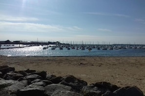 A beach with a rocky foreground and a marina in the background. - Apartment in La Baule near Côte d’Amour (PORNICHET)
