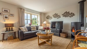 A cozy living room with a sofa, wooden coffee table, and a fireplace.