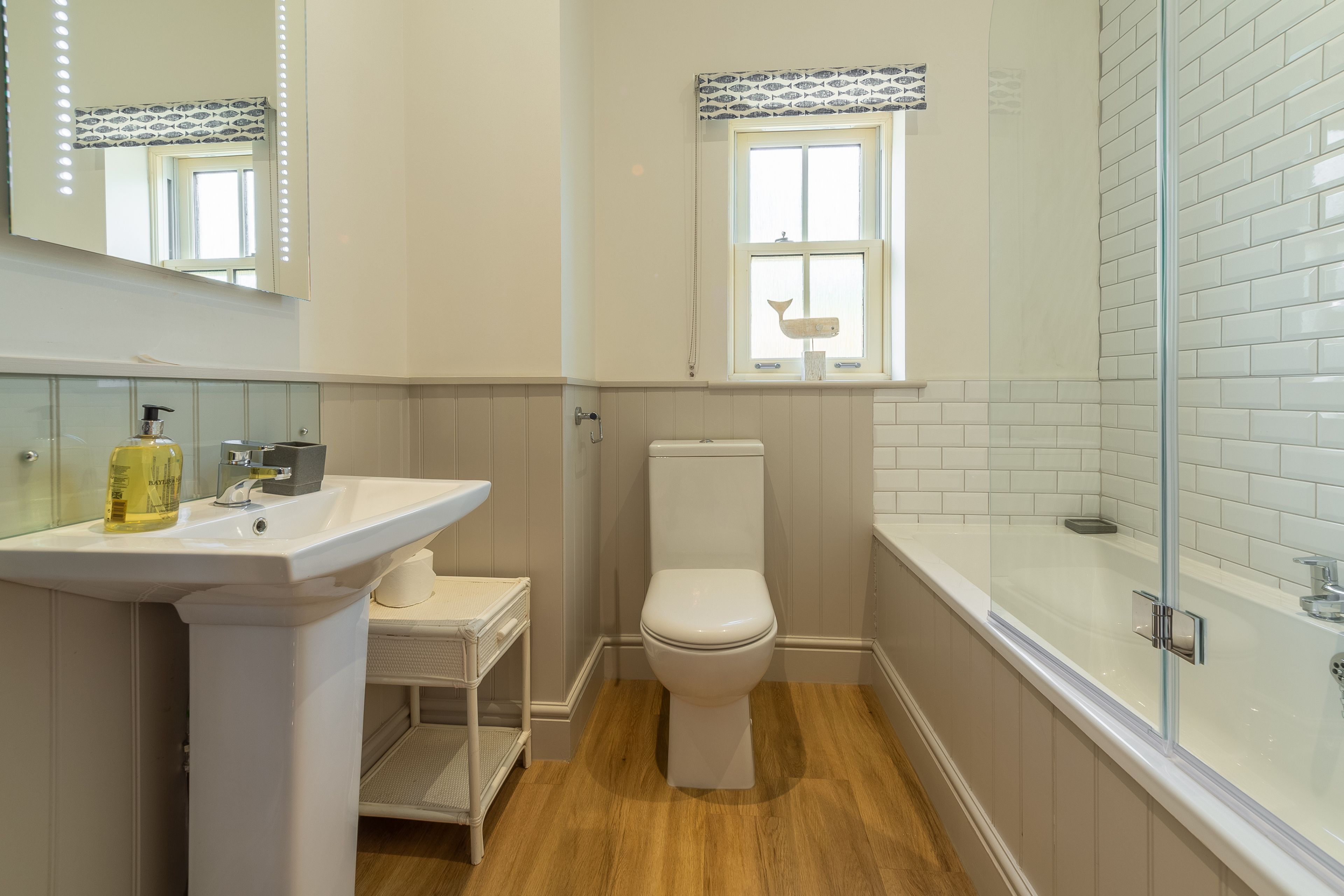 Un bagno con lavandino, WC e vasca da bagno bianchi.