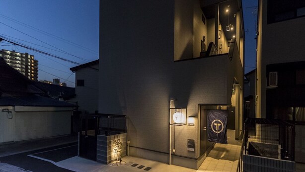 A modern building with a glass facade, a visible entrance, and a small outdoor seating area. - Trip Pod Yoshizuka B (Fukuoka)
