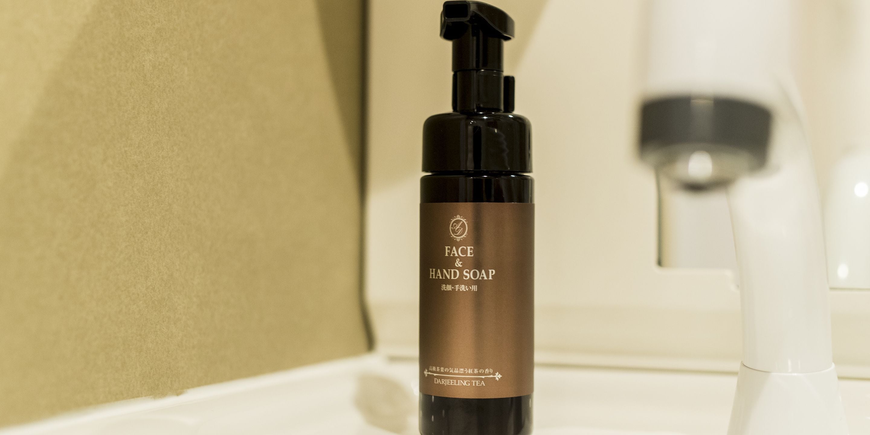 A bottle of face and hand soap on a bathroom counter.