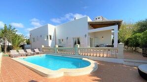 Una casa moderna de dos pisos con piscina, fachada blanca y un patio cubierto.