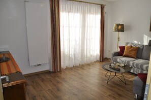 Un salon avec un canapé, une table basse, une lampe et un radiateur.