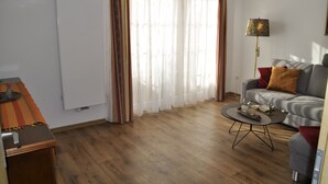 A living room with a sofa, a coffee table, a lamp, and a radiator. - FEWO Geisbergblick, Germany (Strullendorf)