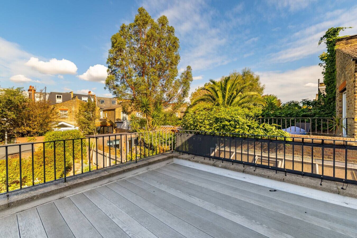 Une terrasse sur le toit offrant une vue sur les bâtiments et les arbres environnants.