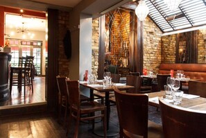A restaurant with brick walls, wooden tables, and chairs.