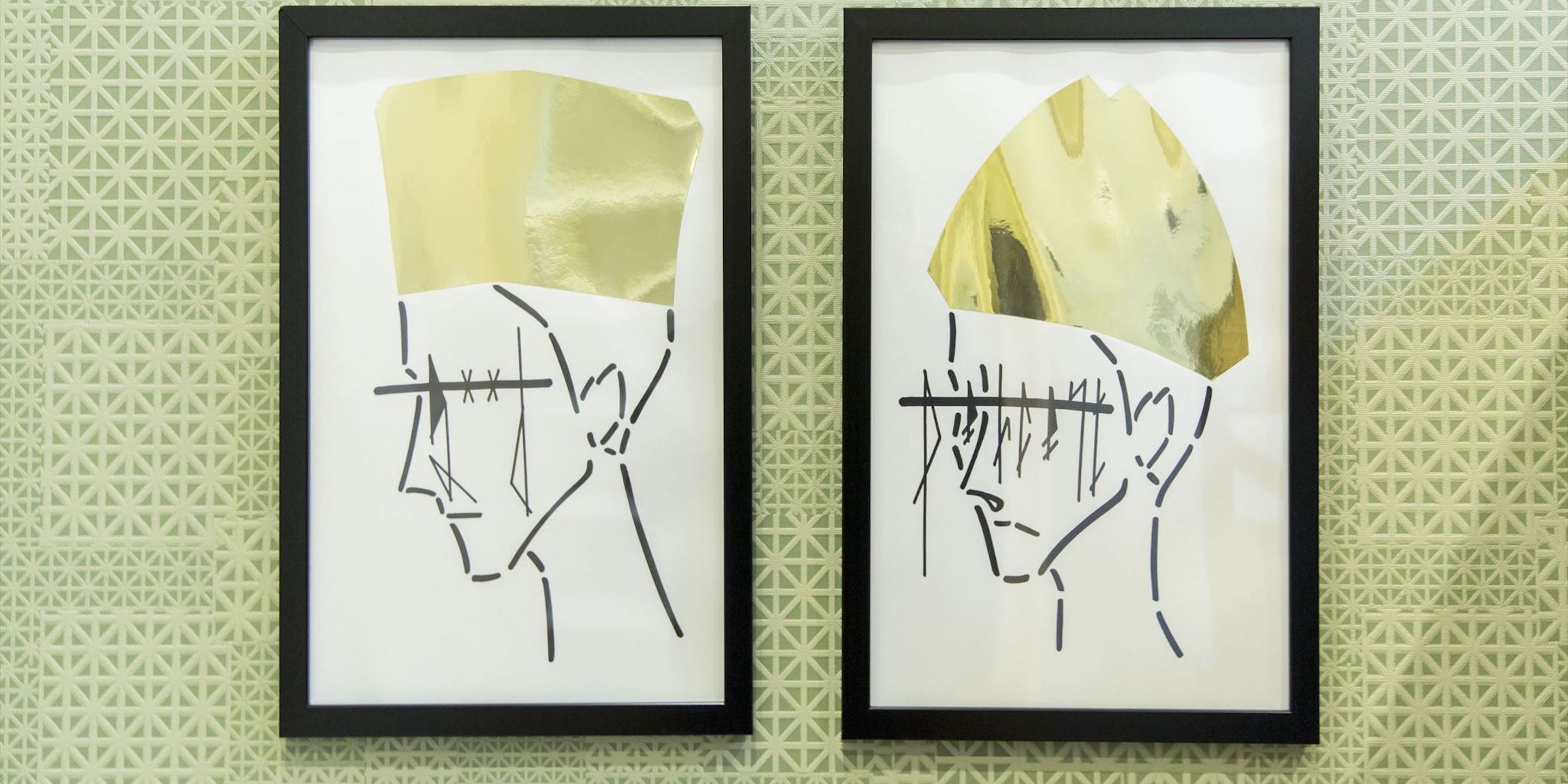 Two framed abstract artworks with geometric patterns on a textured wall.