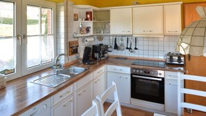 A kitchen with white cabinets, a Bosch dishwasher, a coffee maker, and a toaster. - Single standing top equipped house for up to 14 people. (Battenberg/Dodenau (Eder))