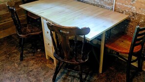 A rustic wooden dining area with a large table and four chairs. - Snug and Cozy Hideaway is close to National Parks, BYU Idaho, and River Beach (St Anthony)