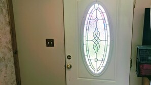 A white door with a stained glass window, a wooden beam ceiling, and a small mat at the entrance. - Snug and Cozy Hideaway is close to National Parks, BYU Idaho, and River Beach (St Anthony)