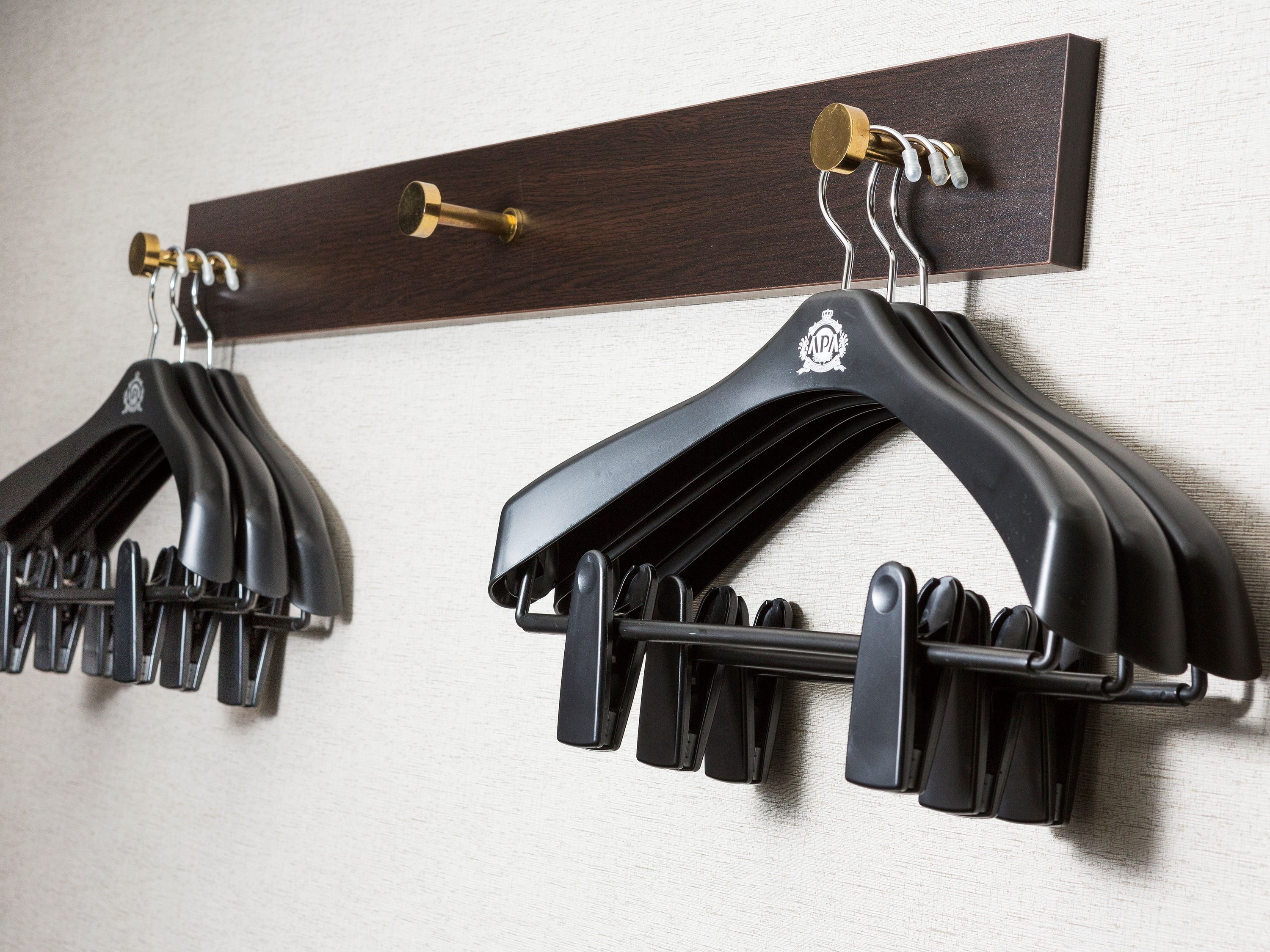 Deux crochets noirs, fixés à un mur en bois.