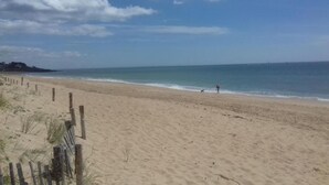 A beach with a wooden fence, a clear sky, and calm sea. - Apartment in La Baule with Sea View (PORNICHET)
