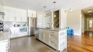 A spacious kitchen with white cabinets, a granite countertop, and a central island.