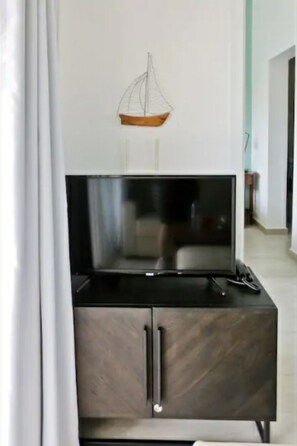 Relax in a contemporary living space with a flat-screen TV and stylish lighting.