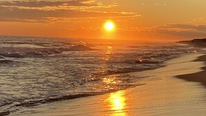 A sunset over a beach with waves reflecting the sun's light. - Hamptons Retreat w/ Pool & Tennis - 90min from NYC (Quogue)