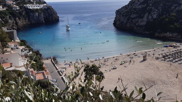 A coastal town with a beach, rocky cliffs, and a marina. - Well-kept vacation home with pool and garden directly on the Cami de Cavalls. (Cala en Porter)