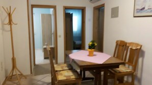 A dining area with a wooden table, chairs, and a small potted plant. - Family holiday fun on the Croatian Mediterranean coast (Privlaka)