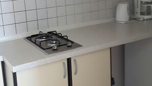 A kitchen with a gas stove, white cabinets, and a coffee maker. - Family holiday fun on the Croatian Mediterranean coast (Privlaka)