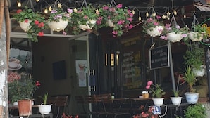 The exterior of the Lapomme Hotel with a signboard, outdoor seating area with tables and chairs, and potted plants. - Diamond Hotel Sapa (Sa Pa)