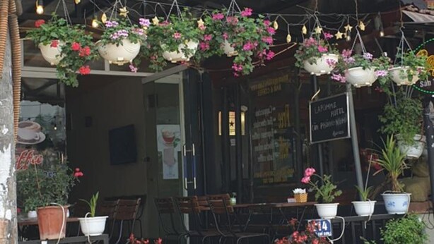 The exterior of the Lapomme Hotel with a signboard, outdoor seating area with tables and chairs, and potted plants. - Diamond Hotel Sapa (Sa Pa)