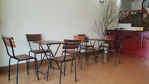 A reception area with a wooden reception desk, several wooden chairs, and a potted plant. - Diamond Hotel Sapa (Sa Pa)