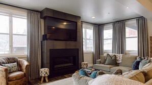 A modern living room with a fireplace, comfortable seating, and large windows. -   Luxury Ski-In/Out Town Lift Walk to Main St (Park City)