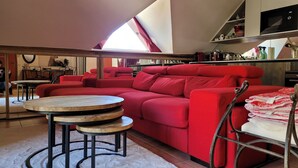 A modern living room with a red sectional sofa, a round wooden coffee table, and a white shag rug. - Beautiful duplex 65m², 6p, balcony, parking, WiFi (Pra-Loup)