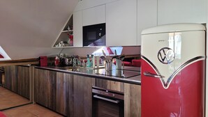 A kitchen with a red refrigerator, a microwave, and a wooden countertop. - Beautiful duplex 65m², 6p, balcony, parking, WiFi (Pra-Loup)