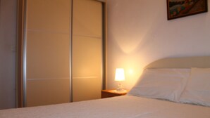 Et hotelværelse med en seng, et natbord med en lampe og et billede på væggen.