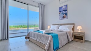 A hotel room with a large bed, a view of the sea, and a painting on the wall. - Coral Beach Villa 5 Bedroom 5 Bathroom 200m from Coast 700m from Coralia Beach (Peyia)