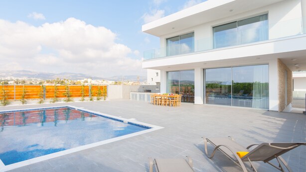 A modern building with a rooftop pool, outdoor seating, and large windows. - Coral Beach Villa 5 Bedroom 5 Bathroom 200m from Coast 700m from Coralia Beach (Peyia)
