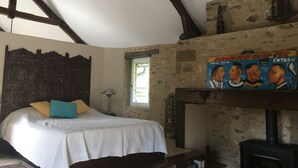 A bedroom with a bed, a wooden headboard, a window, a fireplace, and a wall with a decorative panel. - Périgord - Country house (Beynat)