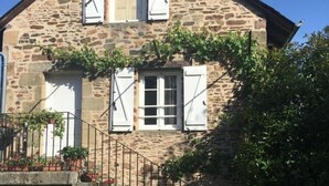 A stone house with a staircase, white shutters, and potted plants. - Périgord - Country house (Beynat)