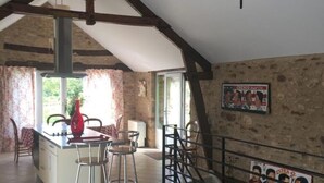 A spacious loft with exposed wooden beams, a kitchen area, and a dining space. - Périgord - Country house (Beynat)