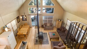 Un loft espacioso con techo alto, ventanas amplias, chimenea y comedor.