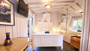 Un dormitorio con una cama grande, una mesita de noche, un espejo y una ventana con cortinas.