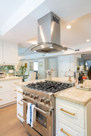 Enjoy cooking in this well-equipped kitchen with an oven, stainless steel range hood, and large island.