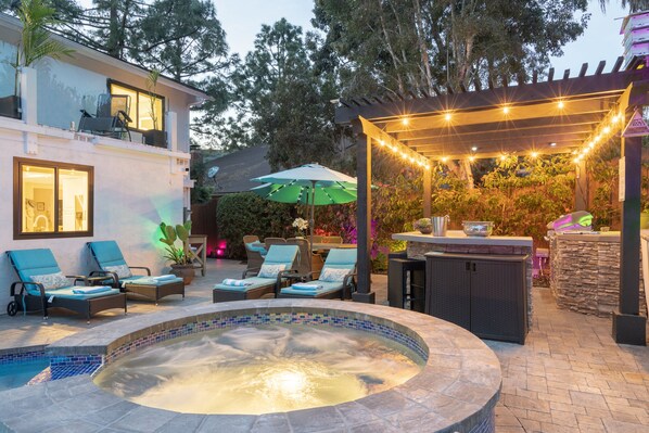 Relax by the pool surrounded by lush greenery and comfortable seating.
