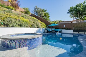 Relax by the pool surrounded by a landscaped hillside and enjoy the hot tub with a mosaic tile design.