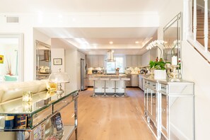 Enjoy cooking in this well-equipped kitchen with a central island, bar stools, and stainless steel range hood.